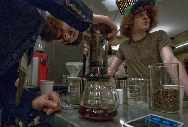 Robbie Krask, left, uses an AeroPress to prepare coffee over ice.