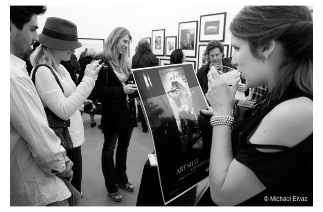 A beauteous magazine writer for LA Weekly, Jennifer Swann, pauses, center, as purchaser of nude Simone poster, on right, examines her acquisition.\r\n